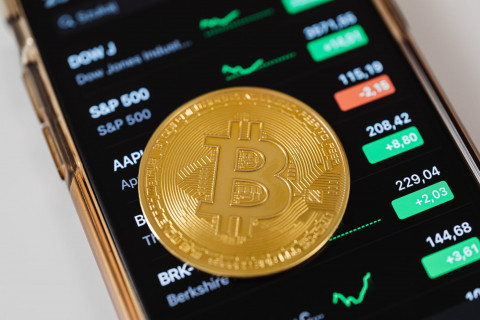 A Bitcoin signage is placed atop the display of crypto currency exchange rates in mobile phone