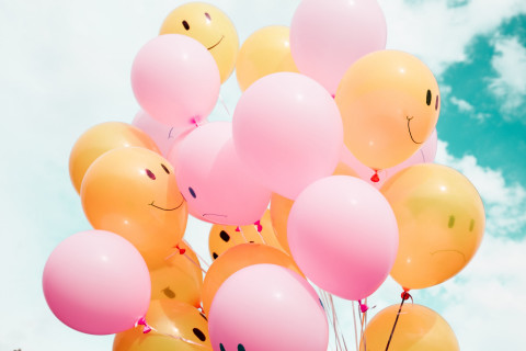 Yellow balloons with happy faces and pink balloons with frowning faces