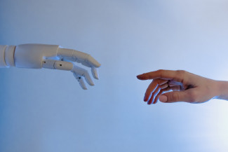 A person reaching out to a robot, imitating Michelangelo's Fresco painting 'Creazione di Adamo' | Image Courtesy: Tara Winstead, Pexels