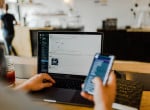 Developer working on laptop while browsing through mobile version of the site. Credit: Austin Distel/Unsplash